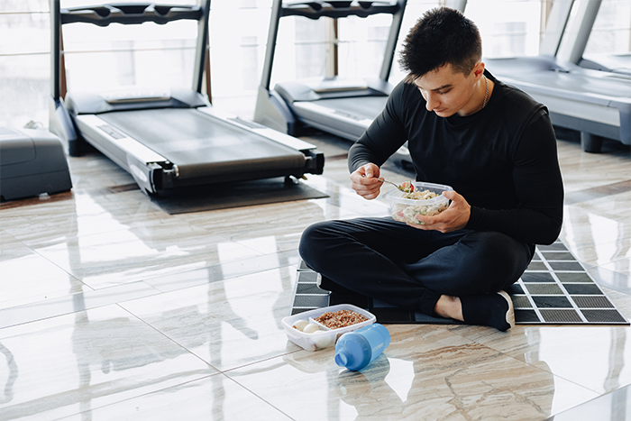 young man eating a well balanced meal before a workout